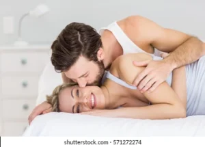 romantic-couple-embracing-on-bed-260nw-571272274